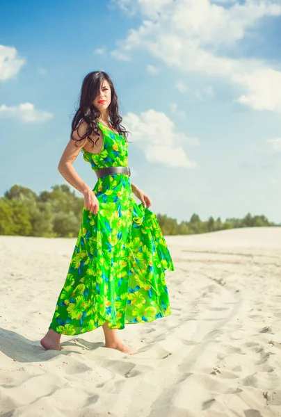 パターンを持つ緑の夏のドレスで砂漠の砂の上の美しい女性 明るい服と終日スタイリッシュな外観のためのスタイル — ストック写真