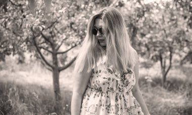 Çekici ve cüsseli genç bayan doğada dinleniyor. Şık giyinmiş genç bir kadının portresi.