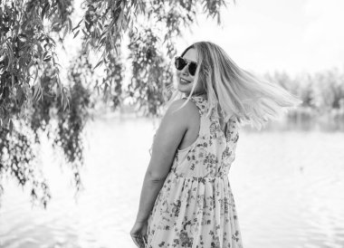 Çekici ve cüsseli genç bayan doğada dinleniyor. Şık giyinmiş genç bir kadının portresi.