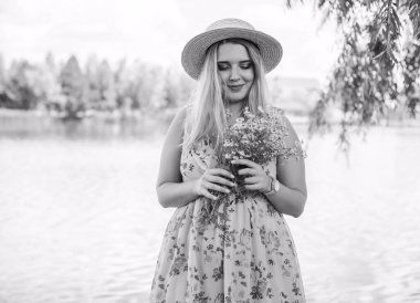 Çekici ve cüsseli genç bayan doğada dinleniyor. Şık giyinmiş genç bir kadının portresi.