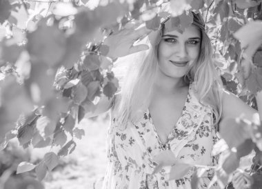 Çekici ve cüsseli genç bayan doğada dinleniyor. Şık giyinmiş genç bir kadının portresi.