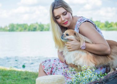 Çekici ve cüsseli genç bayan doğada dinleniyor. Şık giyinmiş genç bir kadının portresi.