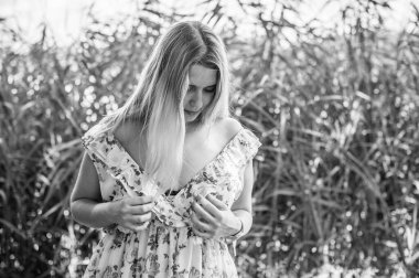 Çekici ve cüsseli genç bayan doğada dinleniyor. Şık giyinmiş genç bir kadının portresi.