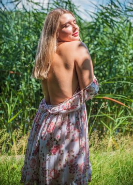 Çekici ve cüsseli genç bayan doğada dinleniyor. Şık giyinmiş genç bir kadının portresi.