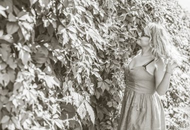 Çekici ve cüsseli genç bayan doğada dinleniyor. Şık giyinmiş genç bir kadının portresi.