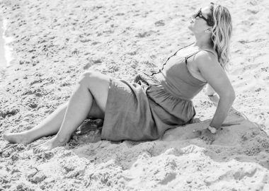 Çekici ve cüsseli genç bayan doğada dinleniyor. Şık giyinmiş genç bir kadının portresi.