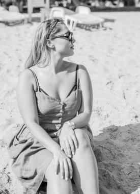 Çekici ve cüsseli genç bayan doğada dinleniyor. Şık giyinmiş genç bir kadının portresi.