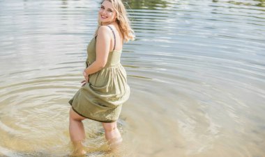 Çekici ve cüsseli genç bayan doğada dinleniyor. Şık giyinmiş genç bir kadının portresi.