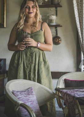 Amerikalı güzel, genç, beyaz saçlı, yeşil elbiseli bir kadın Provence 'ın içiyle mutfakta rahatça oturuyor.