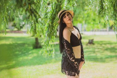 Tatil zamanı. Modern kadın sıcak bir günde hayatın tadını çıkarıyor, konsepti gevşetiyor, yaz günlerini.