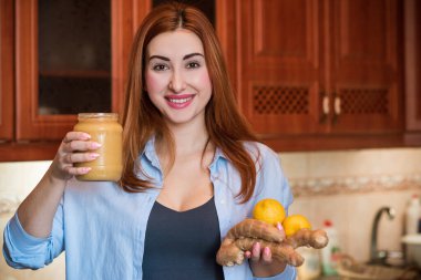 Kadın, limon ve zencefil, çay kavanozu sağlıklı yaşam tarzı, sağlıklı meyve ve vitaminler alır.