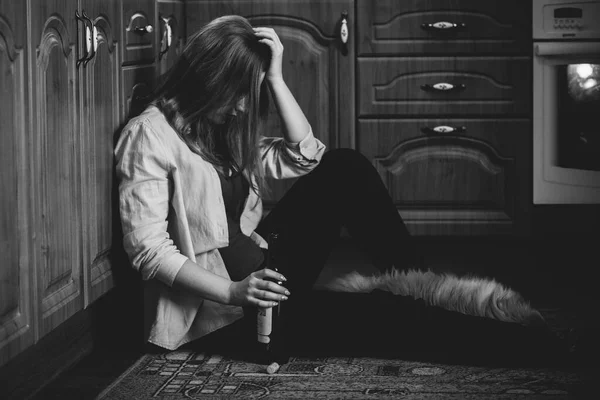 女はうつ病アルコールの問題を抱えてる犬とキッチンの床に座ってる — ストック写真