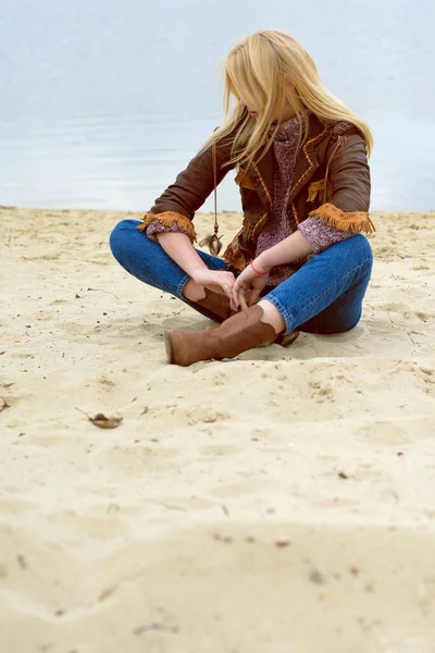 若いですセクシーブロンドの女の子で自然と葦近くA川と木でアメリカのカントリースタイルで革ジャケット セーター青ジーンズと茶色のブーツで美しい顔とかなり目 — ストック写真