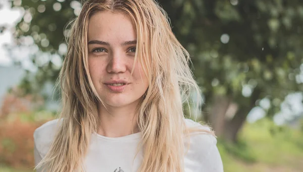 Doğa, yaz tatili, tatil ve insanlar konsepti - gündelik tarzda genç sarışın kız güzel bir hayat düşlüyor ve anın tadını çıkarıyor.