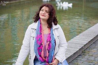 Yetişkin, iri yapılı, Amerikan ya da Avrupa görünümlü basit bir kadın şehirde hayatın tadını çıkarıyor. Fazla kilolu, ceketli ve fularlı hoş bir bayan şehrin eski bir köşesinde dolaşıyor.