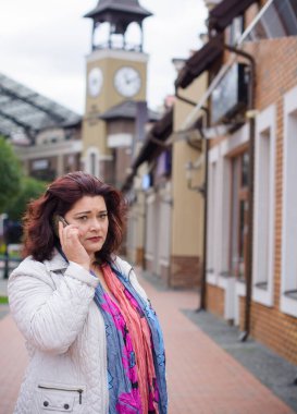 Yetişkin, iri yapılı, Amerikan ya da Avrupa görünümlü basit bir kadın şehirde hayatın tadını çıkarıyor. Fazla kilolu, ceketli ve fularlı hoş bir bayan şehrin eski bir köşesinde dolaşıyor.