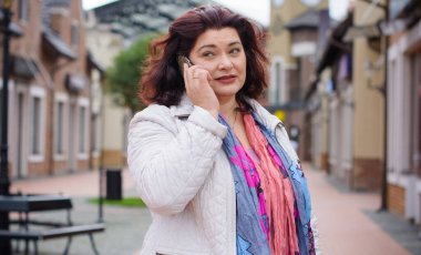 Yetişkin, iri yapılı, Amerikan ya da Avrupa görünümlü basit bir kadın şehirde hayatın tadını çıkarıyor. Fazla kilolu, ceketli ve fularlı hoş bir bayan şehrin eski bir köşesinde dolaşıyor.