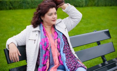 Yetişkin, iri yapılı, Amerikan ya da Avrupa görünümlü basit bir kadın şehirde hayatın tadını çıkarıyor. Fazla kilolu, ceketli ve fularlı hoş bir bayan şehrin eski bir köşesinde dolaşıyor.