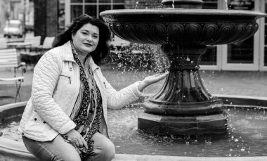 Yetişkin, iri yapılı, Amerikan ya da Avrupa görünümlü basit bir kadın şehirde hayatın tadını çıkarıyor. Fazla kilolu, ceketli ve fularlı hoş bir bayan şehrin eski bir köşesinde dolaşıyor.