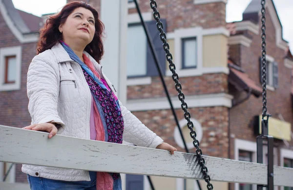 Yetişkin, iri yapılı, Amerikan ya da Avrupa görünümlü basit bir kadın şehirde hayatın tadını çıkarıyor. Fazla kilolu, ceketli ve fularlı hoş bir bayan şehrin eski bir köşesinde dolaşıyor.