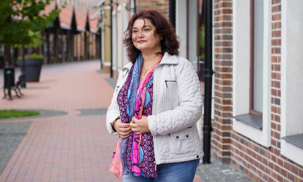 Yetişkin, iri yapılı, Amerikan ya da Avrupa görünümlü basit bir kadın şehirde hayatın tadını çıkarıyor. Fazla kilolu, ceketli ve fularlı hoş bir bayan şehrin eski bir köşesinde dolaşıyor.