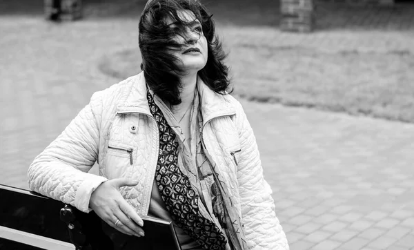 Yetişkin, iri yapılı, Amerikan ya da Avrupa görünümlü basit bir kadın şehirde hayatın tadını çıkarıyor. Fazla kilolu, ceketli ve fularlı hoş bir bayan şehrin eski bir köşesinde dolaşıyor.