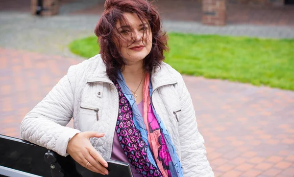 Yetişkin, iri yapılı, Amerikan ya da Avrupa görünümlü basit bir kadın şehirde hayatın tadını çıkarıyor. Fazla kilolu, ceketli ve fularlı hoş bir bayan şehrin eski bir köşesinde dolaşıyor.