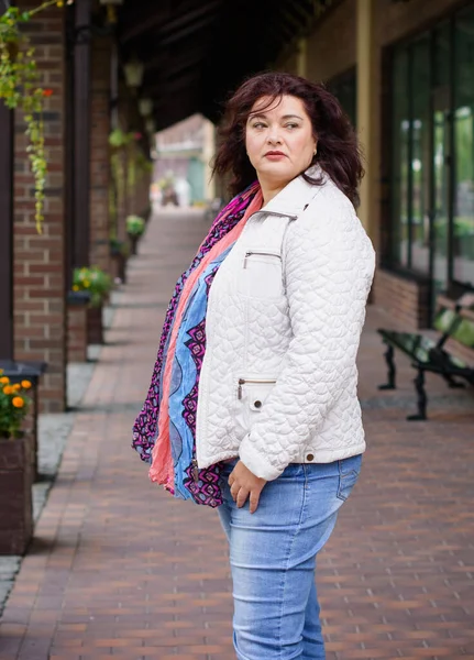 Yetişkin, iri yapılı, Amerikan ya da Avrupa görünümlü basit bir kadın şehirde hayatın tadını çıkarıyor. Fazla kilolu, ceketli ve fularlı hoş bir bayan şehrin eski bir köşesinde dolaşıyor.