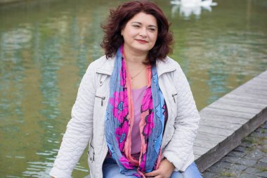 Yetişkin, iri yapılı, Amerikan ya da Avrupa görünümlü basit bir kadın şehirde hayatın tadını çıkarıyor. Fazla kilolu, ceketli ve fularlı hoş bir bayan şehrin eski bir köşesinde dolaşıyor.