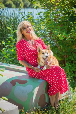 Corgi 'nin güzel köpeği olan kadın yürüyüşe çıkmış. Köpeklerin hayatı. Evcil hayvanlar en iyi arkadaştır. 