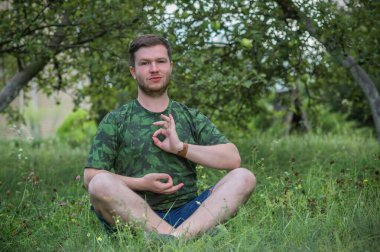 Doğada meditasyon yapan genç bir adam. Yeni dünyanın insanları, zamanı değiştiriyor.