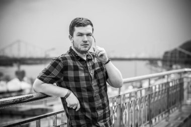 Ciddi ruh hali olan genç adam şehir manzarasına bak, tombul insanlar konsepti, büyük şehir hayatı. Şehir merkezindeki adamın resmi