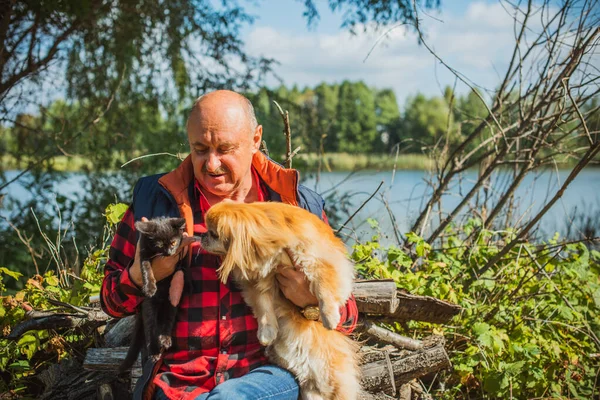 Senior man on retired, dog lover with his red pekingese pet on a walk at park. Concept love and care of animals. Good people caring for pets