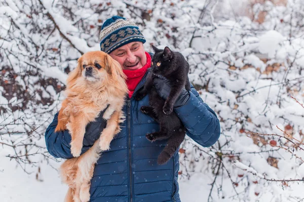 Senior man on retired, dog lover with his red pekingese pet on a walk at park. Concept love and care of animals. Good people caring for pets