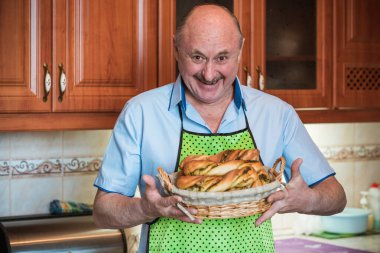 Mutfakta elinde bir sepet ekmek, hobi ve emeklilik hayatında iyi bir ruh haliyle gülümseyen son sınıf öğrencisi.