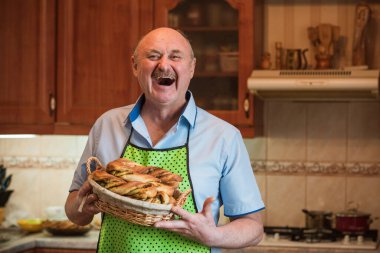 Mutfakta elinde bir sepet ekmek, hobi ve emeklilik hayatında iyi bir ruh haliyle gülümseyen son sınıf öğrencisi.