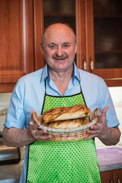 Mutfakta elinde bir sepet ekmek, hobi ve emeklilik hayatında iyi bir ruh haliyle gülümseyen son sınıf öğrencisi.