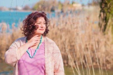 Çekici ve olgun bir kadının portresi. Güneşli bir sonbahar gününde gündelik tarzda yürüyüp bir şeyler düşünüyor. 40-50 yıl sonra kadın hayatı