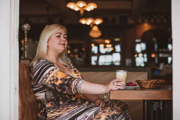 Restoranda genç, zarif, iri yarı bir kadın. Bayan randevuyu romantik bir havada bekler. Kalın vintage tonlarda portre