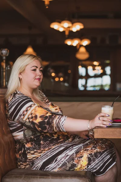 Restoranda genç, zarif, iri yarı bir kadın. Bayan randevuyu romantik bir havada bekler. Kalın vintage tonlarda portre