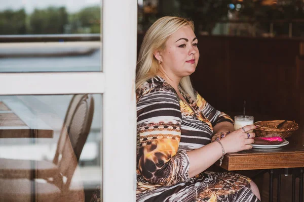 Restoranda genç, zarif, iri yarı bir kadın. Bayan randevuyu romantik bir havada bekler. Kalın vintage tonlarda portre