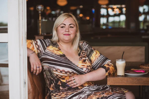 Restoranda genç, zarif, iri yarı bir kadın. Bayan randevuyu romantik bir havada bekler. Kalın vintage tonlarda portre