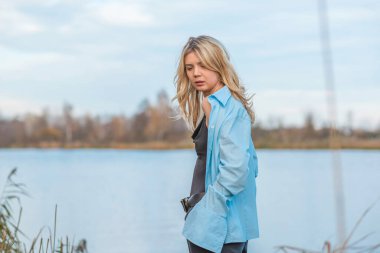 Gölde dinlenen bir kadın, oldukça güzel bir manzara. Rahat gömlekli kız, rahatlama zamanı.