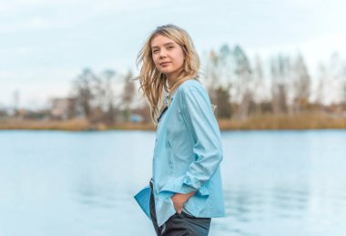 Gölde dinlenen bir kadın, oldukça güzel bir manzara. Rahat gömlekli kız, rahatlama zamanı.