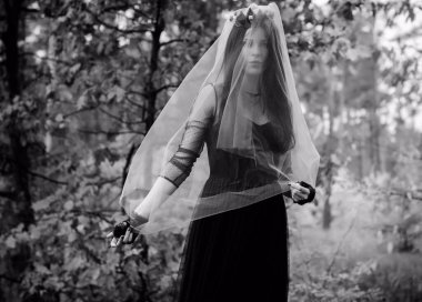 Karanlık bir ormanda cadılar bayramı cadısı. Modern cadılar gibi giyinmiş güzel bir kadın. Cadılar Bayramı sanat tasarımı. Cadılar Bayramı Konsepti için karanlık tema