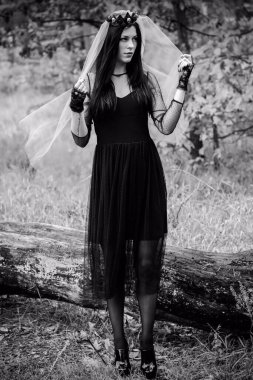 Karanlık bir ormanda cadılar bayramı cadısı. Modern cadılar gibi giyinmiş güzel bir kadın. Cadılar Bayramı sanat tasarımı. Cadılar Bayramı Konsepti için karanlık tema