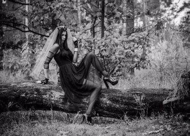 Karanlık bir ormanda cadılar bayramı cadısı. Modern cadılar gibi giyinmiş güzel bir kadın. Cadılar Bayramı sanat tasarımı. Cadılar Bayramı Konsepti için karanlık tema