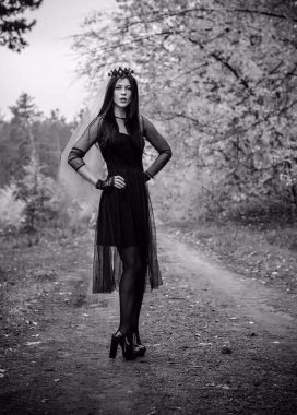 Karanlık bir ormanda cadılar bayramı cadısı. Modern cadılar gibi giyinmiş güzel bir kadın. Cadılar Bayramı sanat tasarımı. Cadılar Bayramı Konsepti için karanlık tema