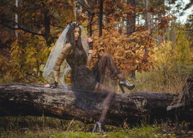 Karanlık bir ormanda cadılar bayramı cadısı. Modern cadılar gibi giyinmiş güzel bir kadın. Cadılar Bayramı sanat tasarımı. Cadılar Bayramı Konsepti için karanlık tema