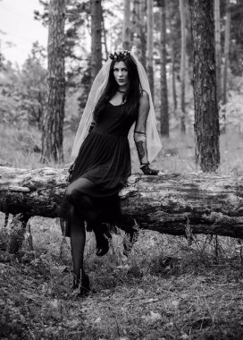 Karanlık bir ormanda cadılar bayramı cadısı. Modern cadılar gibi giyinmiş güzel bir kadın. Cadılar Bayramı sanat tasarımı. Cadılar Bayramı Konsepti için karanlık tema